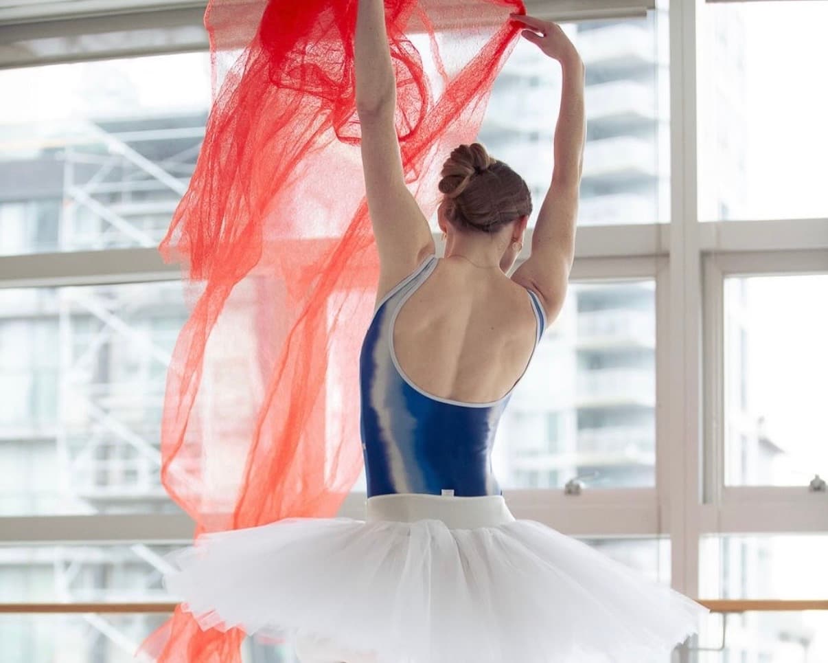 Dancer in blue leotard with red fabric